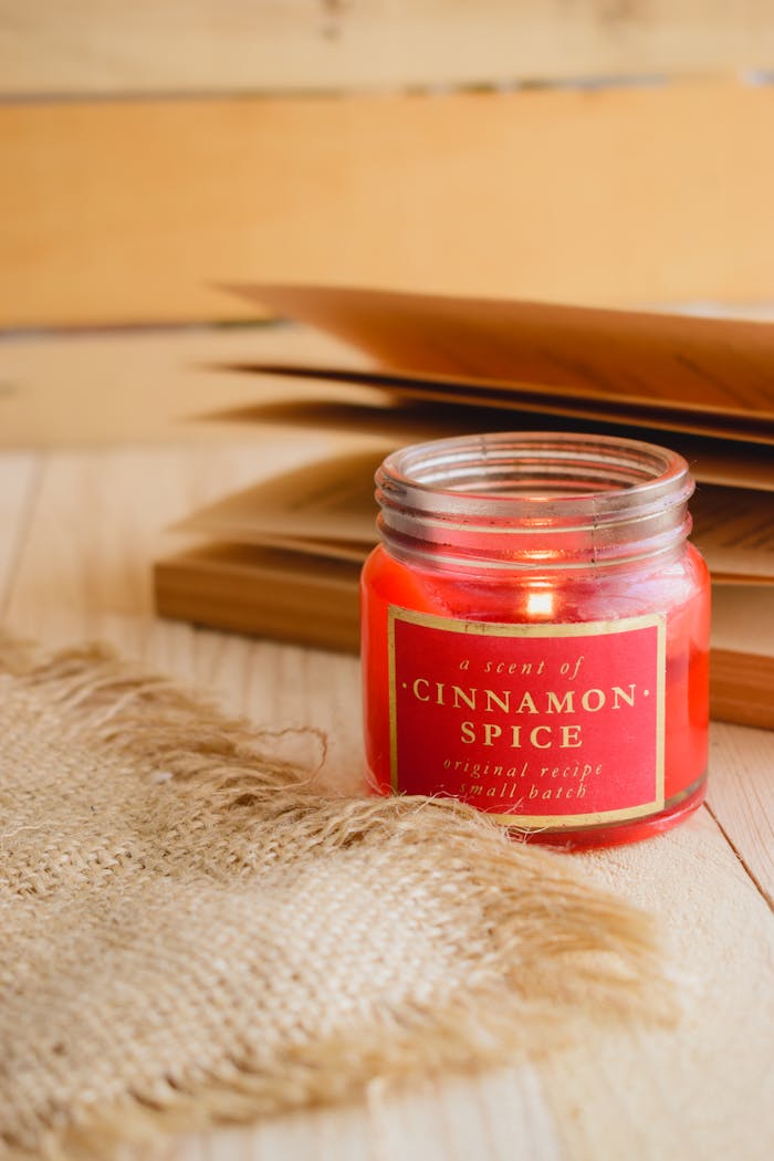 Warm autumn ambiance with a cinnamon-scented candle and book pages.